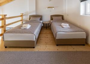 two twin beds in a room with a table at KING rooms in Bečej
