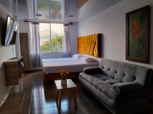 a living room with a couch and a bed at Hospedarte Cali Sur in Cali
