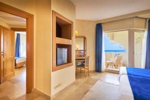 a bedroom with a bed and a television and a table at Nahrawess Resort & Thalasso in Hammamet