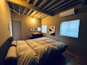 a bedroom with a bed in a room with a window at AGASA residence in Fujieda