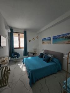 a bedroom with a blue bed and a chair at B&B Kasia in Palmadula