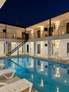 a swimming pool with chairs and a house at Han Dalyan Hotel in Dalyan