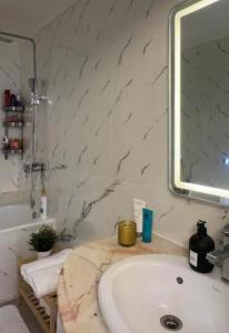 a bathroom with a sink and a mirror at Charme appartement in Mohammedia +8 photos