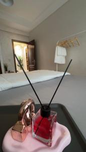 a vase with sticks in it on a table in a bedroom at Charme appartement in Mohammedia