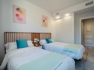 two beds in a hotel room with blue pillows at Casa Lauri in Orihuela Costa +23 photos