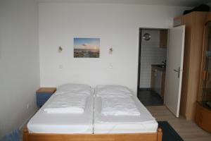 a bed in a room with a white wall at FW Knütel Nr 57 in Burgtiefe auf Fehmarn 