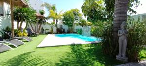 a yard with a swimming pool and a statue next to a house at Angkor Wat Village in Puerto Real