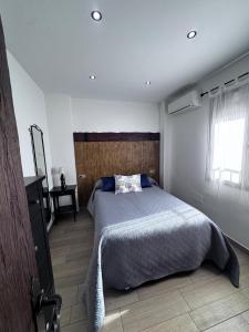 a bedroom with a large bed with a wooden headboard at Los Toneles in Puerto de Santa Cruz