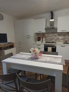 a kitchen with a white table and chairs in a room at Rifugio nel Borgo in Grosseto