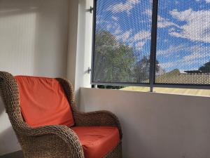 a wicker chair sitting in front of a window at Piero House in Villa Mercedes