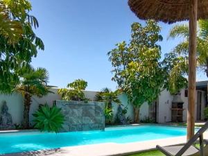 a swimming pool in front of a house with trees at Angkor Wat Village in Puerto Real
