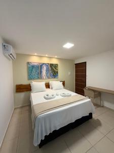 a bedroom with a large bed with two plates on it at Maré Suítes Maragogi in Maragogi
