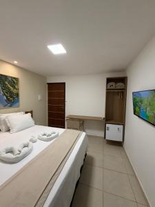a bedroom with a large bed with two towels on it at Maré Suítes Maragogi in Maragogi