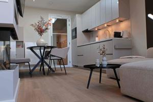 a living room with a table and chairs and a kitchen at Huize Zondag in Beneden-Leeuwen