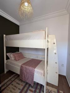 a bedroom with a bunk bed and a chandelier at Cosy aprt in Hammamet Nord