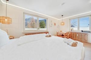 a white bedroom with two beds and a table at Zuhause am Kurgarten in Bad Reichenhall
