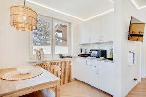 a kitchen with white cabinets and a table and chairs at Zuhause am Kurgarten in Bad Reichenhall