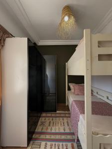 a bedroom with a bunk bed and a chandelier at Cosy aprt in Hammamet Nord +3 photos