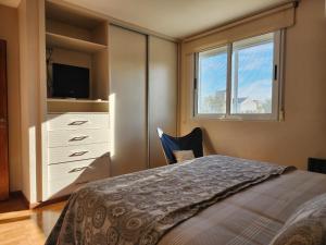 a bedroom with a bed and a dresser and a window at Piero House in Villa Mercedes +10 photos