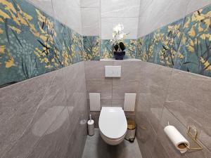 a bathroom with a toilet and a vase with flowers at Szybowcowa View Apartment in Jelenia Góra +2 photos
