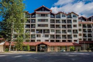 a large white apartment building with a tree at Mountain studio ASP E63 Borovets Gardens in Borovets