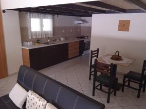 ein Wohnzimmer mit Sofa und Tisch und eine Küche in der Unterkunft Alkion Platana in Kími