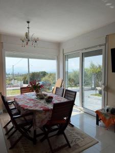 a dining room with a table and chairs and windows at Vila PANORAMA in Karianí