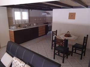 eine Küche mit Sofa und Tisch mit Stühlen in der Unterkunft Alkion Platana in Kími