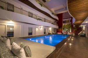 a large swimming pool in a large room with a couch and a couch at In Fashion Hotel & Spa in Playa del Carmen
