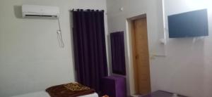 a room with a purple curtain and a door at Eden Plus Executive Hotel Lahore in Lahore