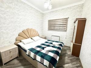 a bedroom with a bed with a tufted headboard at Three Home in Quba
