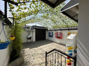 an outdoor patio with an arbor with a building at Three Home in Quba +4 photos