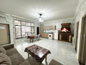 a living room with a table and a fireplace at Three Home in Quba