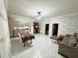 a living room with a table and a couch at Three Home in Quba