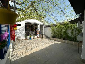 an outdoor patio with an arbor and a building at Three Home in Quba