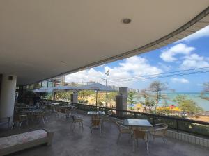 um restaurante com mesas e cadeiras e vista para o oceano em Beira Mar Suite em Fortaleza