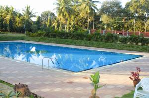 uma piscina com um baloiço num quintal em Royal Orchid Resort & Convention Centre, Yelahanka Bangalore em Bangalore