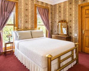 a bedroom with a large bed and a window at The Kalamazoo House Downtown Hotel and Suites in Kalamazoo