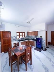 a kitchen with a table and chairs in a room at Sandora Home Stay in Varkala
