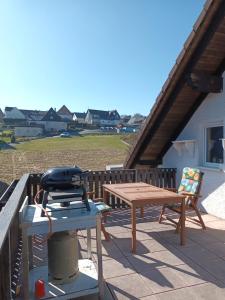 a grill and a picnic table on a patio at Erholsame Westerwälder Ferienwohnung in Weitefeld
