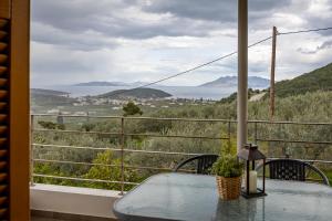 a table on a balcony with a view of the ocean at Aricobé in Ancient Epidauros