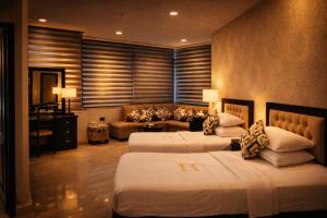 a hotel room with two beds and a couch at Panorama Amman Hotel in Amman +17 photos