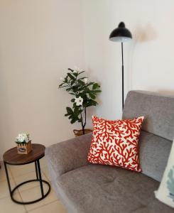 a couch with a red and white pillow in a living room at Seaside Breeze Apartment in Sitia +75 photos