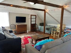 a living room with a couch and a tv at Quaco Cottages-The Shipbuilder's Cottage-Two Century Old Charm in Saint Martins