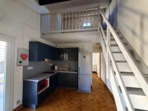 a kitchen with blue cabinets and a loft at maison individuelle in Le Grau-du-Roi