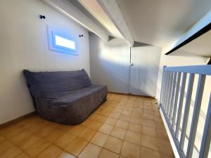 a living room with a couch in the corner at maison individuelle in Le Grau-du-Roi