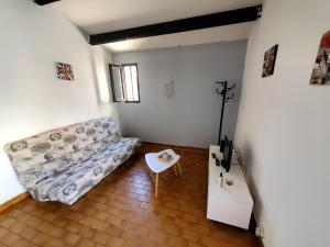 a living room with a couch and a table at maison individuelle in Le Grau-du-Roi