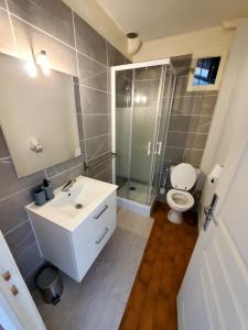 a bathroom with a white sink and a toilet at maison individuelle in Le Grau-du-Roi