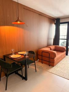 a living room with a table and a couch at Apartamento 1 quarto Goiânia in Goiânia