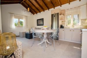 a kitchen and dining room with a table and chairs at Petit Palace in Lefkimmi